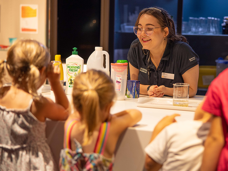 Staff member demonstrating activity to kids