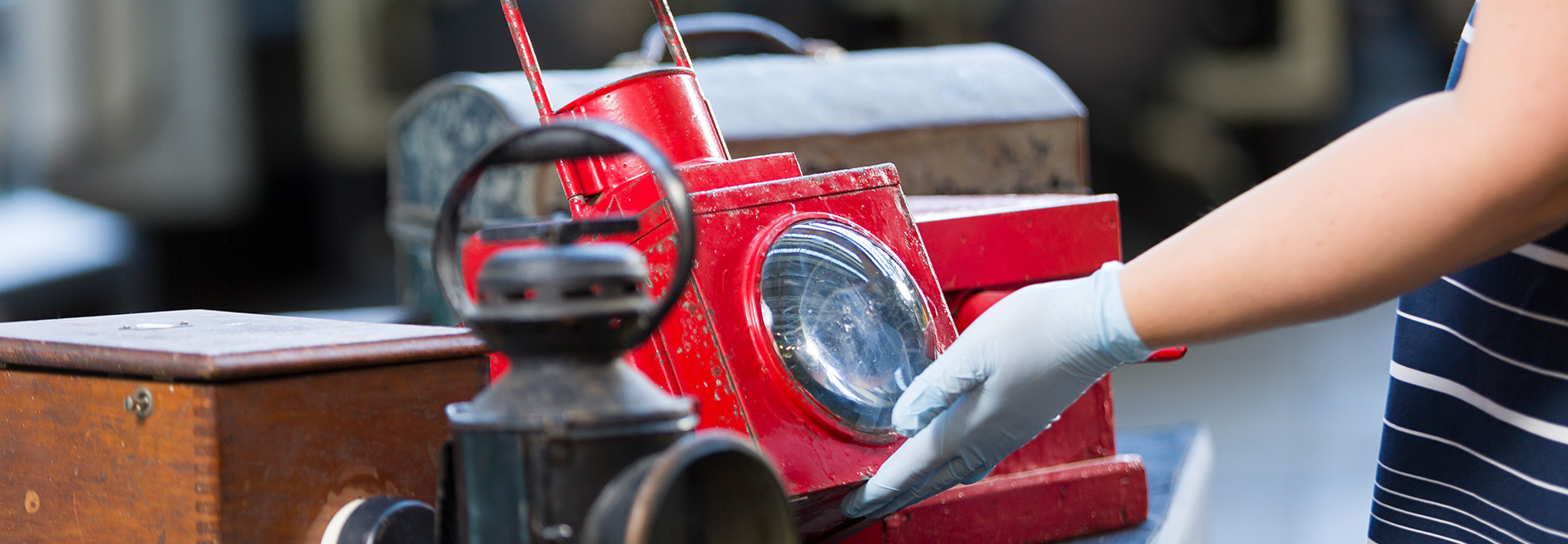 a person wearing gloves inspects a red signal light 